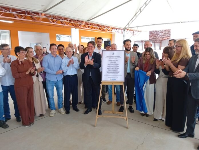 Autoridades aplaudem diante da placa de inauguração da Escola Municipal Emiliano de Souza, no Santa Luzia
