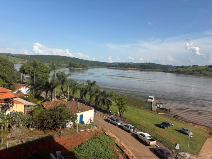 Vista da margem do lago, com barcos e rua, no Pontalete (MG)